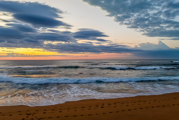 Seaside Sunrise Under a Cloud-Filled Sky