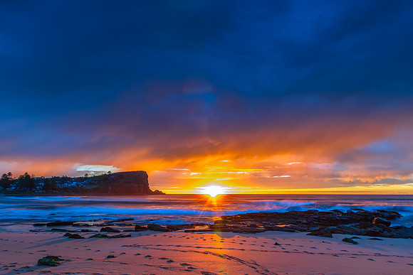 Winter sunrise by the sea shore with rain clouds