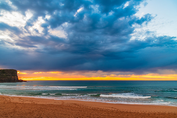 Winter sunrise by the sea shore with rain clouds
