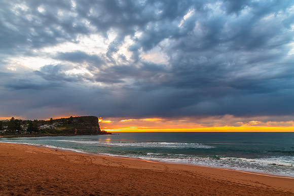 Winter sunrise by the sea shore with rain clouds