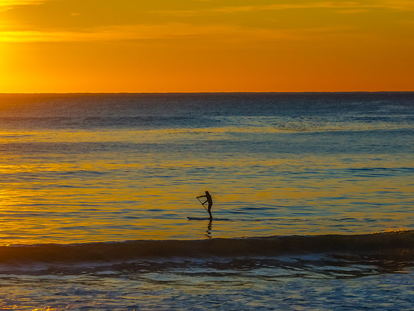 Ocean Sunrise Under Clear Skies with Orange Horizon