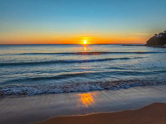 Ocean Sunrise Under Clear Skies with Orange Horizon