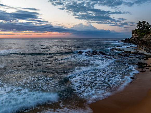 Seaside Sunrise Under a Cloud-Filled Sky