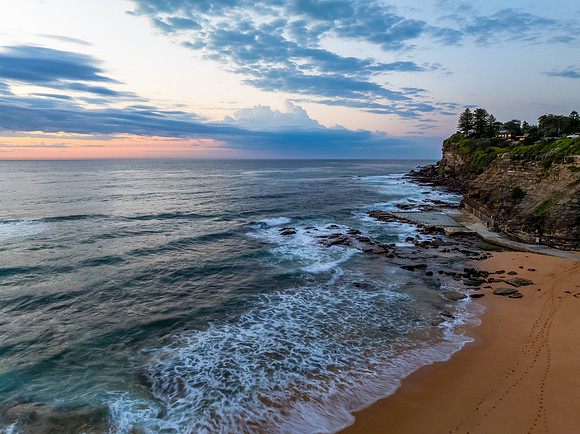 Seaside Sunrise Under a Cloud-Filled Sky