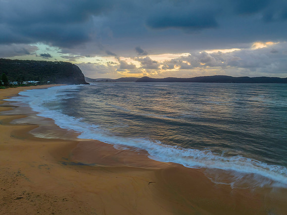Sunrise seascape with overcast sky and rain clouds