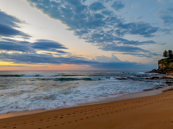 Seaside Sunrise Under a Cloud-Filled Sky