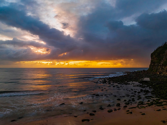 Drizzly moody sunrise seascape with cloud filled sky