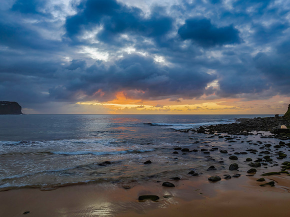 Drizzly moody sunrise seascape with cloud filled sky
