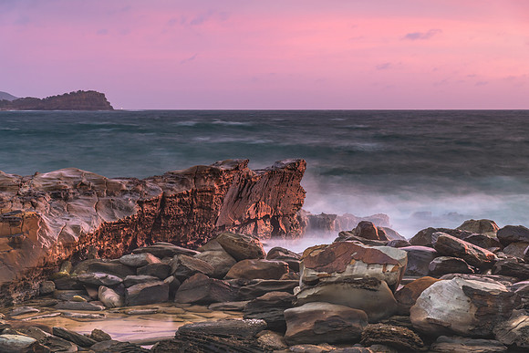 Cloud covered sunrise seascape with rocks