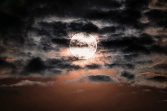 The Harvest Moon supermoon rises illuminating the cloud covered