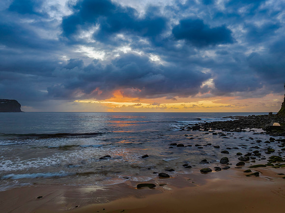 Drizzly moody sunrise seascape with cloud filled sky