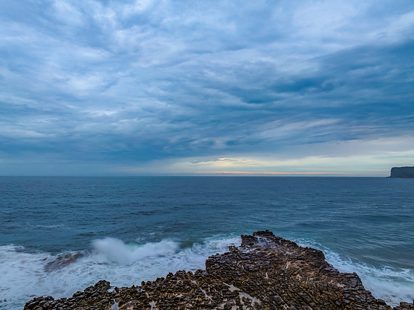 Rainy day sunrise seascape and rock platform