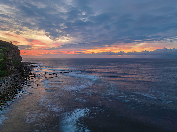 Pastel cloud covered sunrise seascape