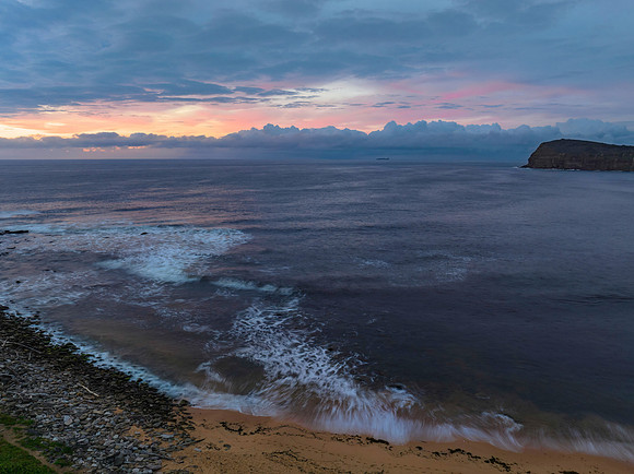 Pastel cloud covered sunrise seascape