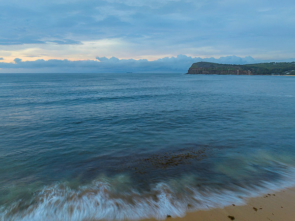 Pastel cloud covered sunrise seascape