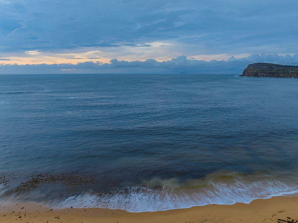 Pastel cloud covered sunrise seascape