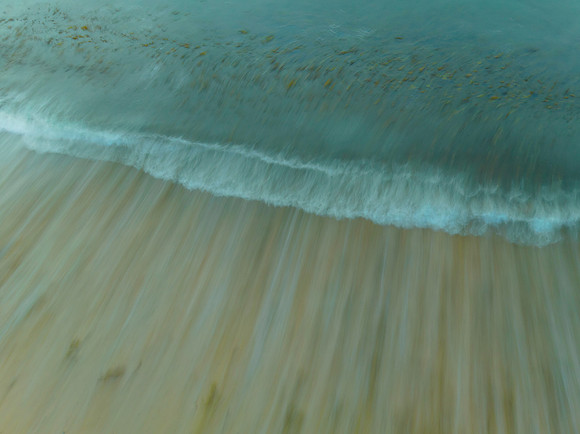 Top down long exposure of the sea and seaweed at the beach