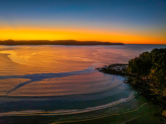 Aerial sunrise seascape with orange glow on a cold Winter's morn