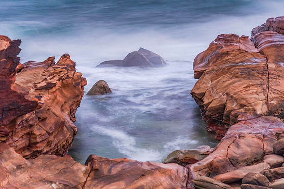 Cloud covered sunrise seascape with rocks