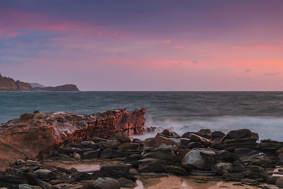 Cloud covered sunrise seascape with rocks