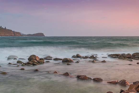 Cloud covered sunrise seascape with rocks