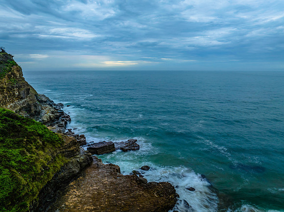 Rainy day sunrise seascape and rock platform