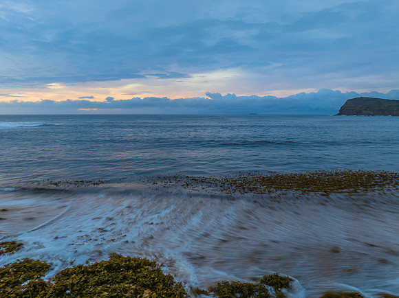 Pastel cloud covered sunrise seascape