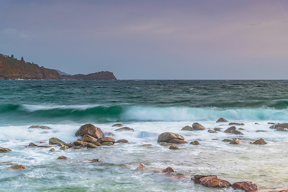 Cloud covered sunrise seascape with rocks