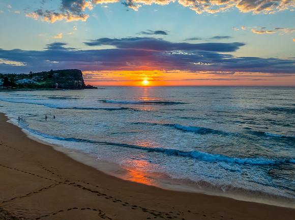 Seaside Sunrise Under a Cloud-Filled Sky