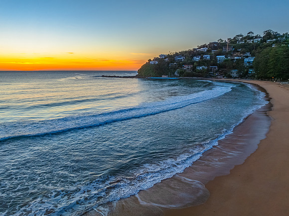 Ocean Sunrise Under Clear Skies with Orange Horizon