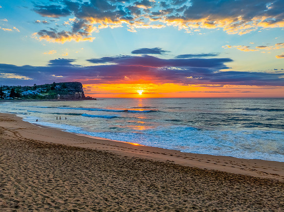 Seaside Sunrise Under a Cloud-Filled Sky