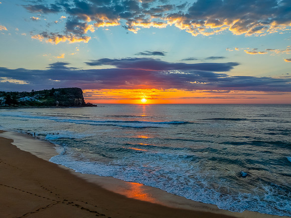 Seaside Sunrise Under a Cloud-Filled Sky