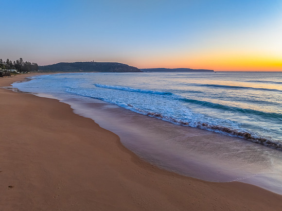 Ocean Sunrise Under Clear Skies with Orange Horizon