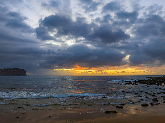 Drizzly moody sunrise seascape with cloud filled sky