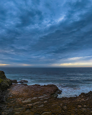 Rainy day sunrise seascape and rock platform