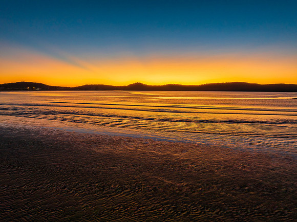 Aerial sunrise seascape with orange glow on a cold Winter's morn