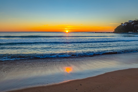 Ocean Sunrise Under Clear Skies with Orange Horizon