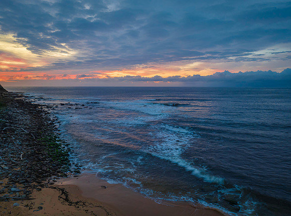 Pastel cloud covered sunrise seascape