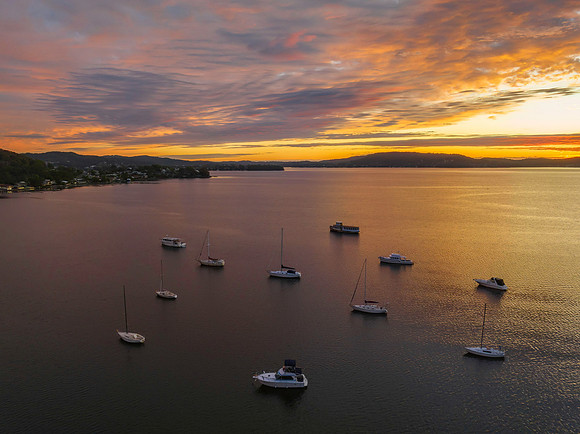 Aerial sunrise over the bay with boats and clouds