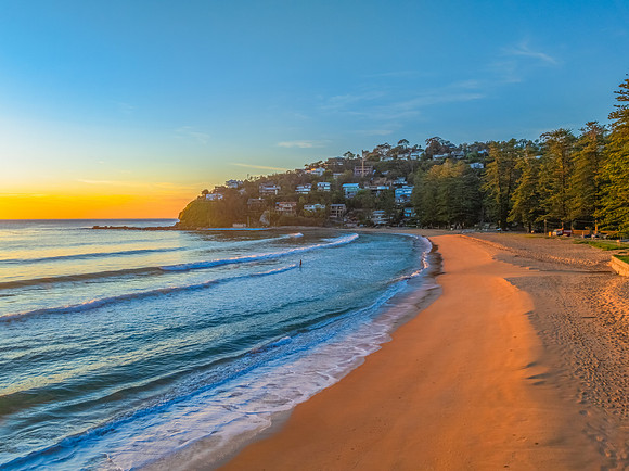 Ocean Sunrise Under Clear Skies with Orange Horizon