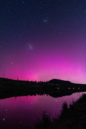Aurora Australis display lights up the sky in pinks over the dam