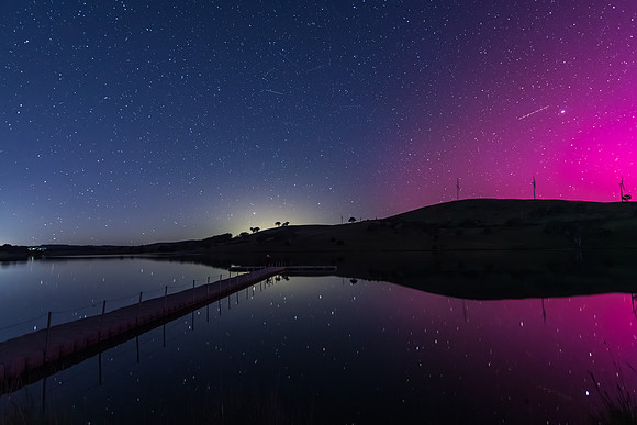 Aurora Australis display lights up the sky in pinks over the dam