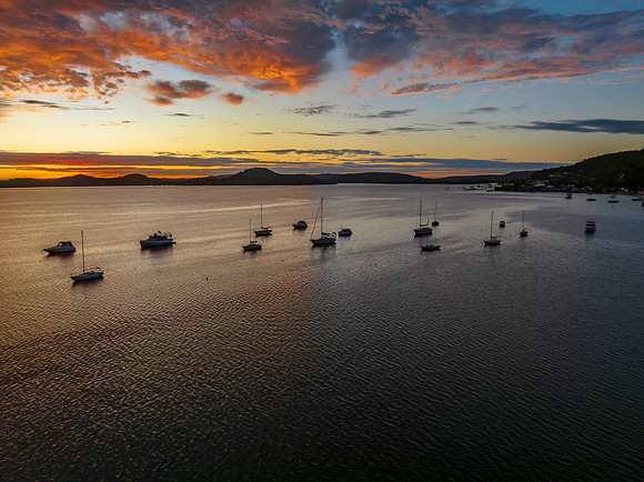 Aerial sunrise over the bay with boats and clouds