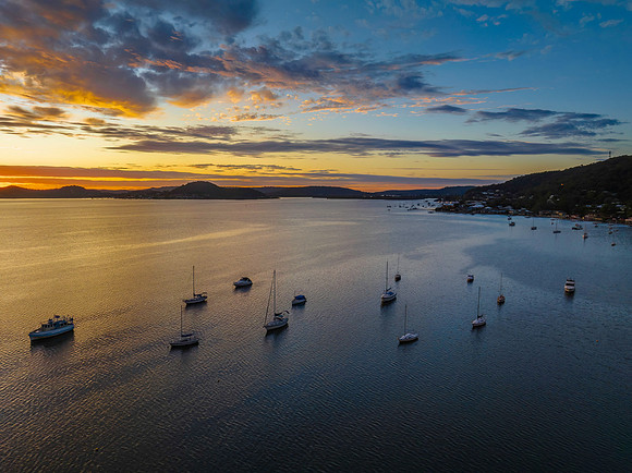 Aerial sunrise over the bay with boats and clouds