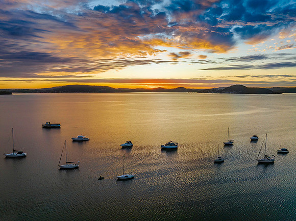 Aerial sunrise over the bay with boats and clouds