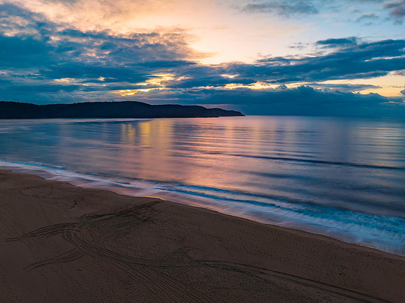 Aerial sunrise seascape with rain clouds