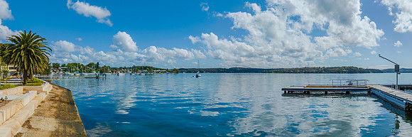 Morning waterfront views with clouds, boats and the blue lake wa