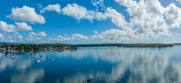 Morning waterfront views with clouds, boats and the blue lake wa