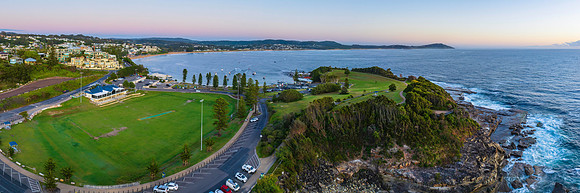 Aerial Sunrise over Coastal Suburb with sports ground, sea and t