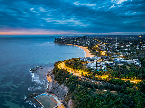 Seaside Sunrise with rain clouds, sea pool, headlands and houses
